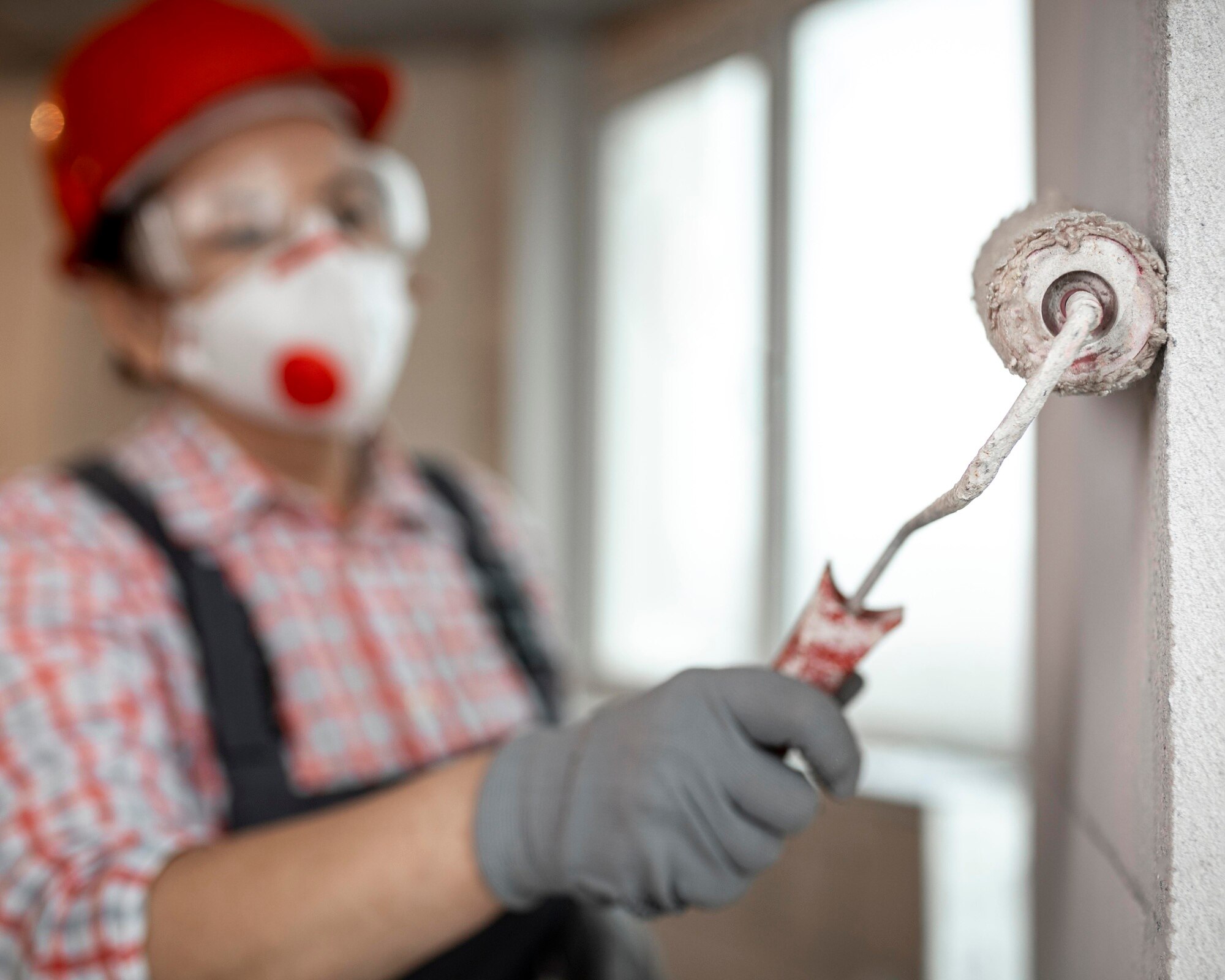 trabajador-construccion-femenina-casco-rodillo-pintura